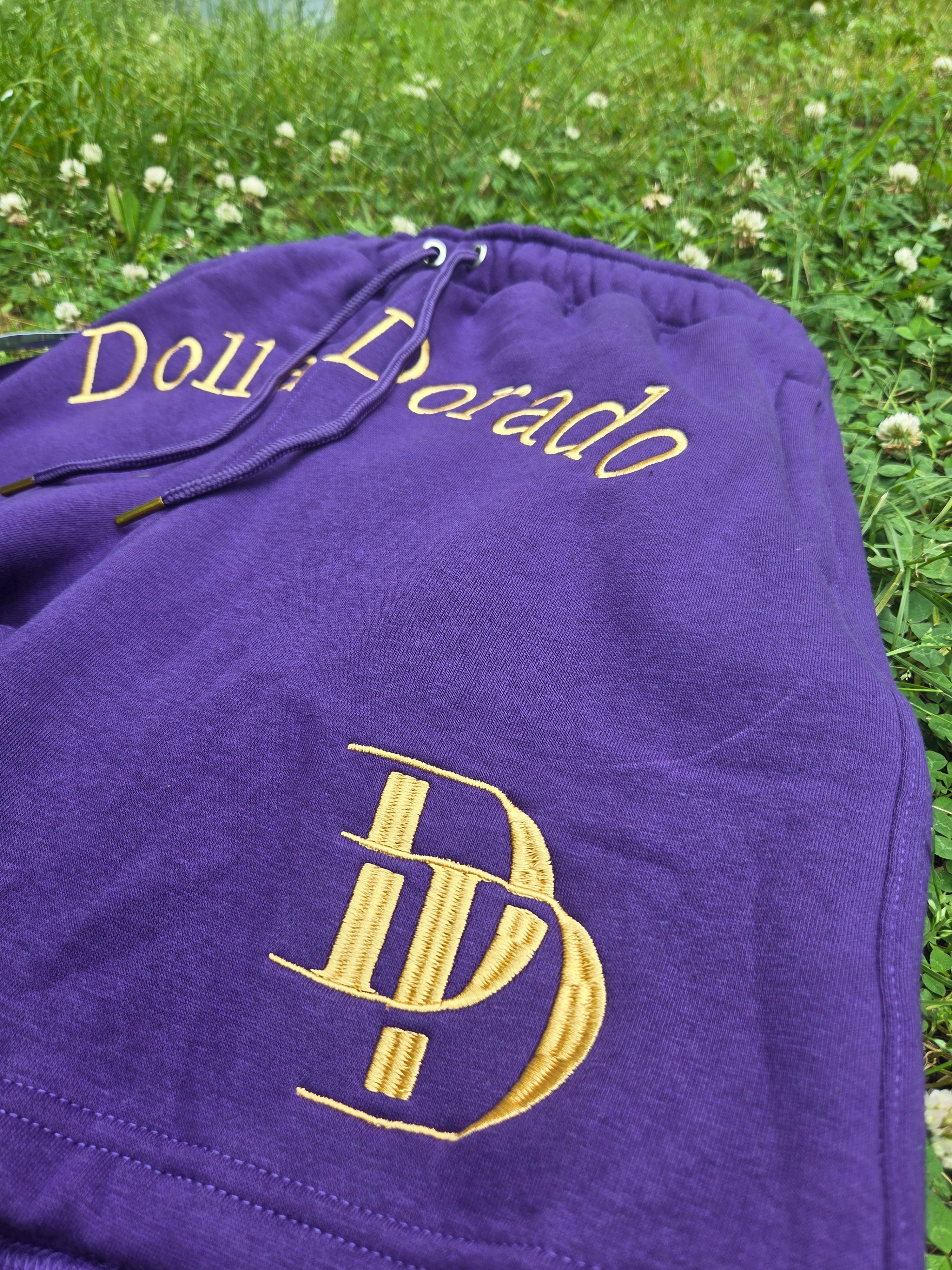 "DollarDorado" shorts (thick fleece). Logo and "DD" lettering embroidered in gold thread. Laces with gold metal tips. Navy blue (15 units available). 2 sizes S, 5 sizes M, 8 sizes L. Limited edition. Limited purple sizes: 3 small, 5 medium, 7 large